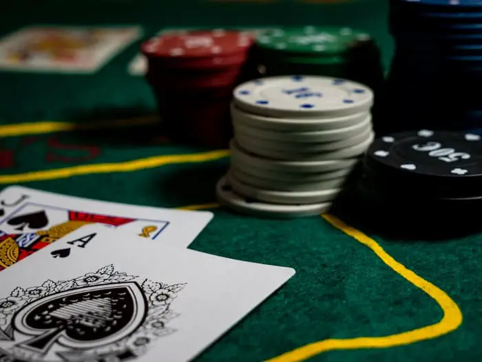 Closeup of poker chips and cards on a game table.