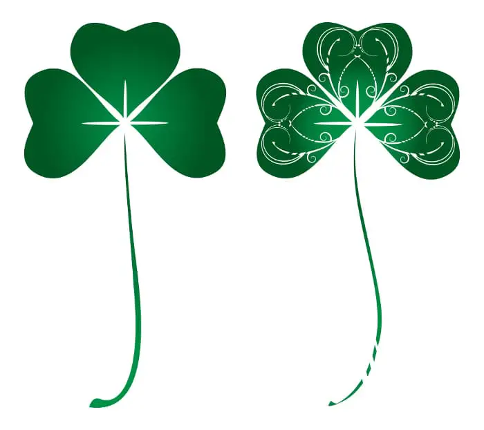 A pair of green shamrocks that each have the suggestion of light shining from the middle where the leaves join.  The shamrock on the right has additional embellishment with lots of curves and curlicues on the leaves.