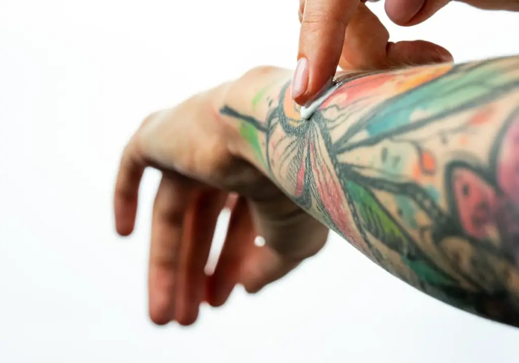 Person applying product to tattoo on arm. Tattoo Goo has a line of aftercare for your tattoos.