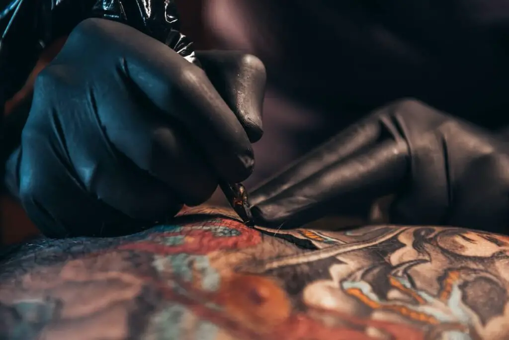 Tattoo artist using a tattoo gun.