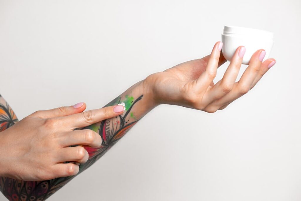 Applying cream to a tattoo. Creams are some of the best tattoo aftercare products.