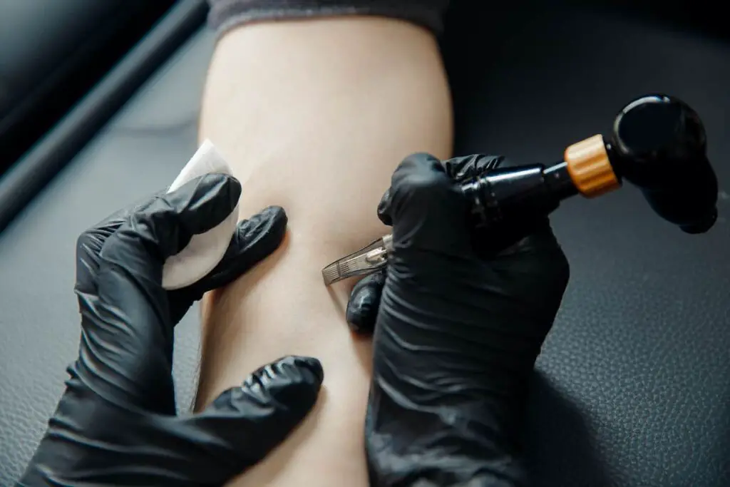 A tattoo artist preparing to begin tattoo work.