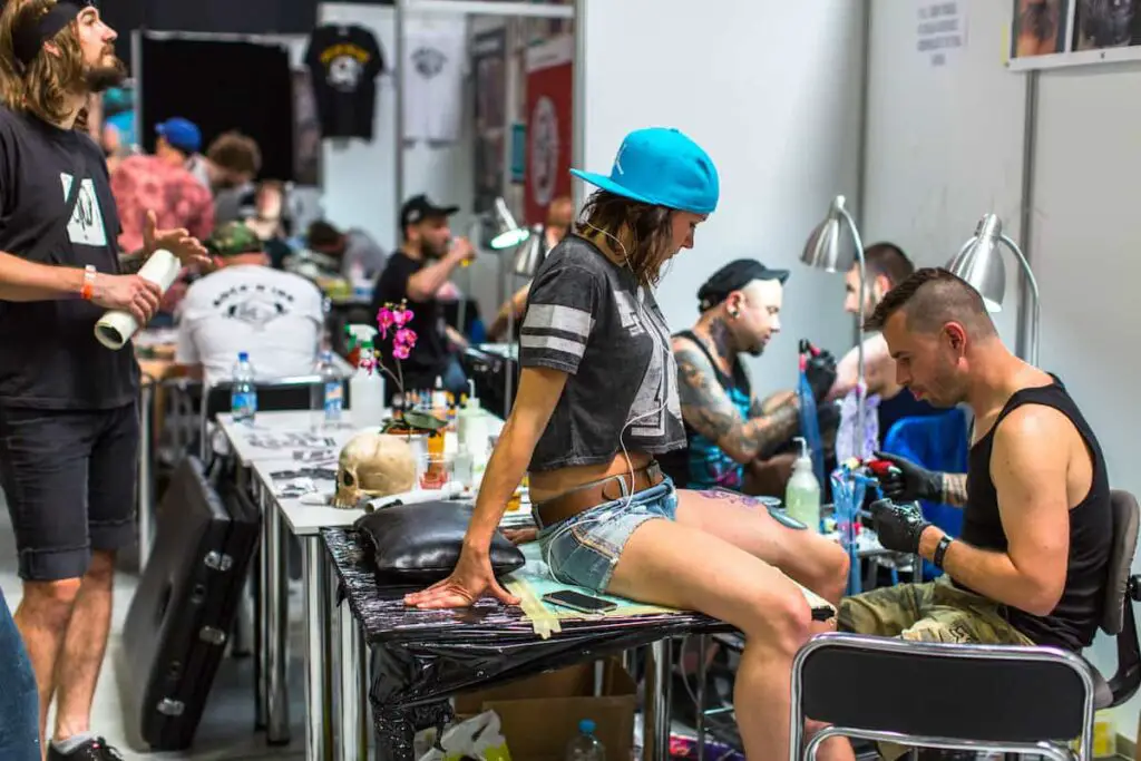 Tattoo artists working at a tattoo convention.