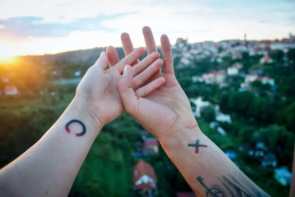 A couple tattoo with an X on one person's wrist and and O on the other person's wrist.