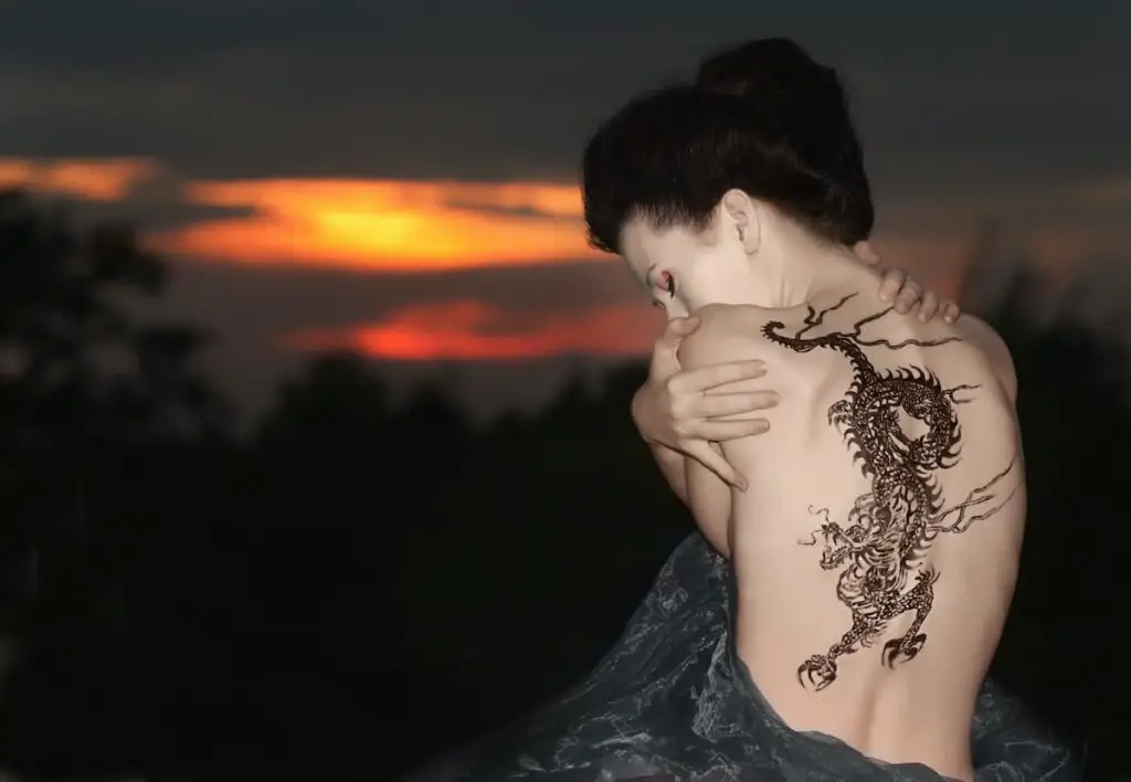 A woman with an intricate dragon tattoo on her back.