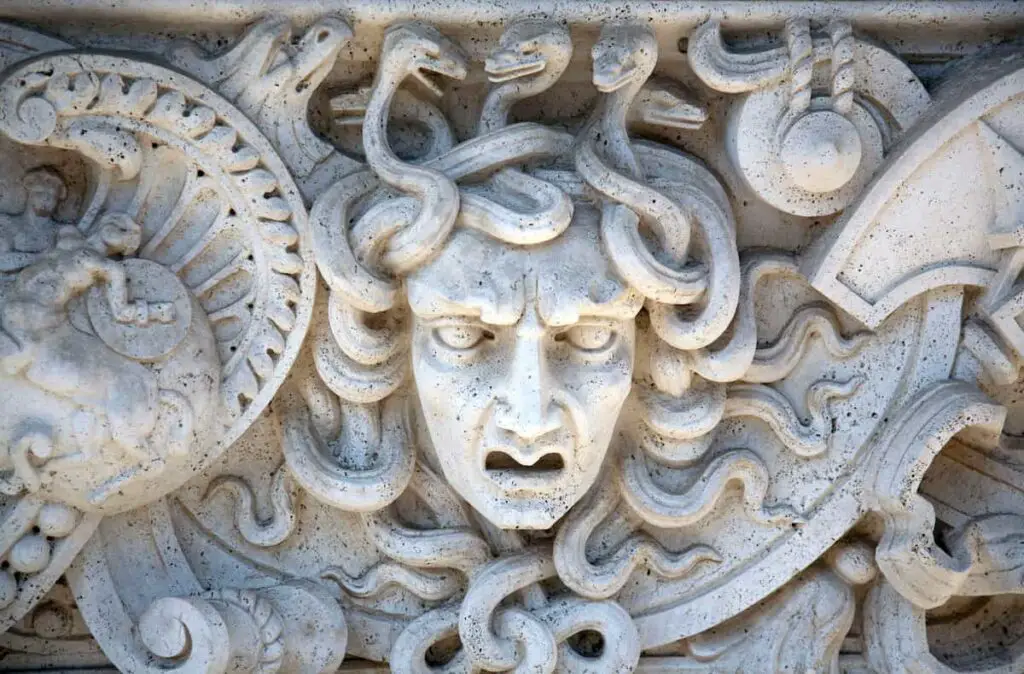 A stone carving of the face and snake hair of Medusa.