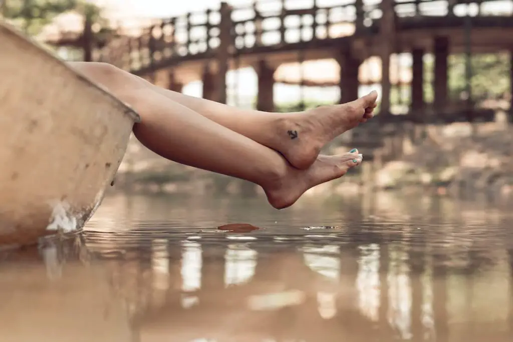 A woman with a small anchor tattoo just below her inner ankle.