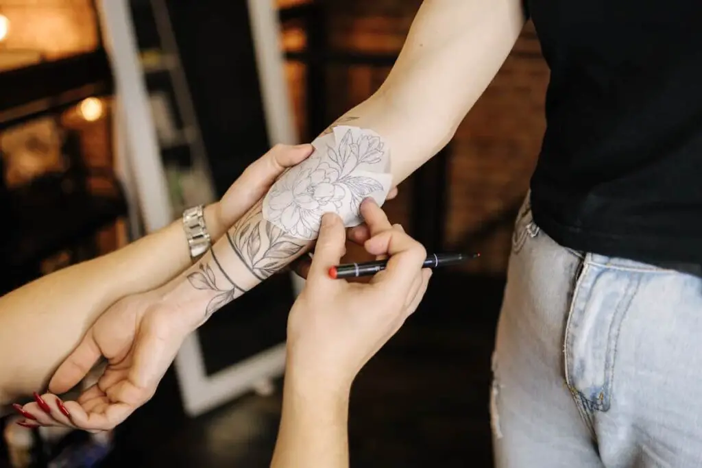A tattoo artist applying a tattoo stencil.