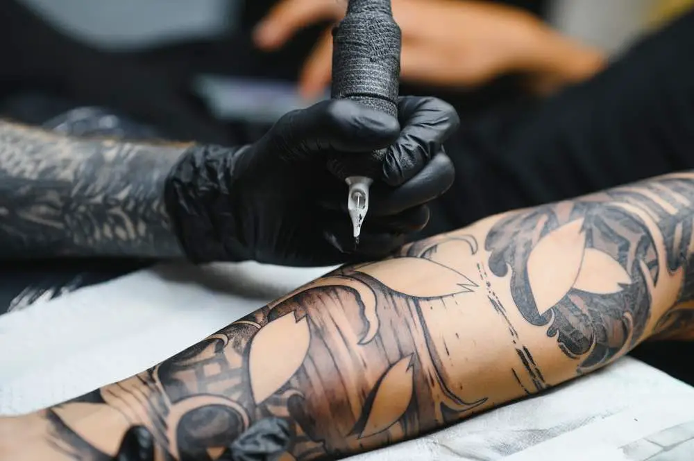 Man getting tattooed by a tattooist