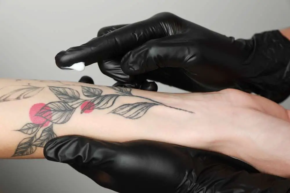 applying cream on arm with tattoo