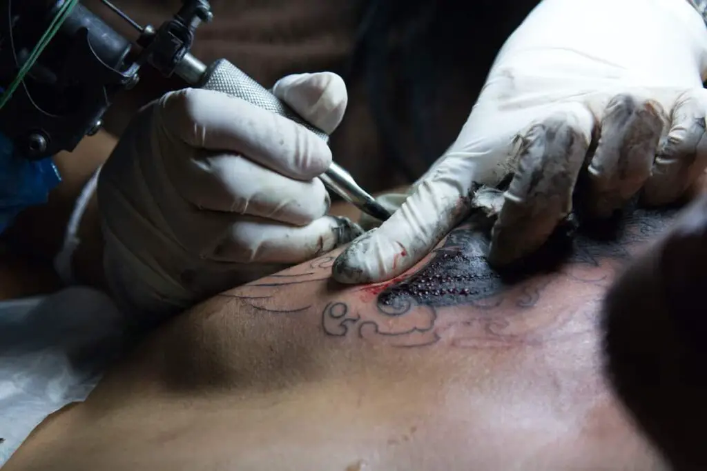 Tattoo artist working on tattoo.
