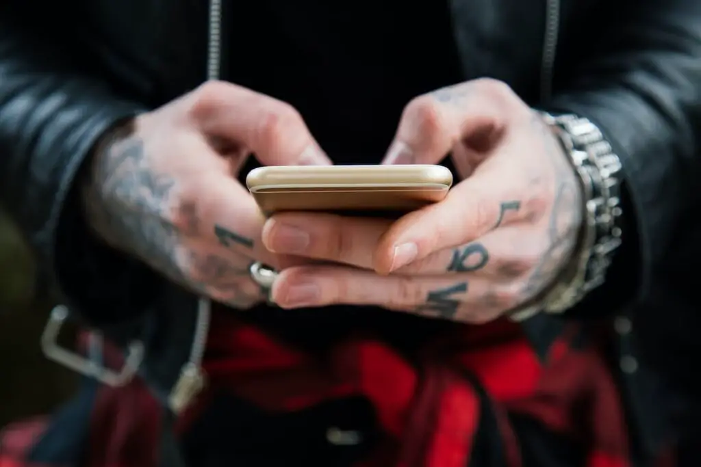 Tattooed man using smartphone.