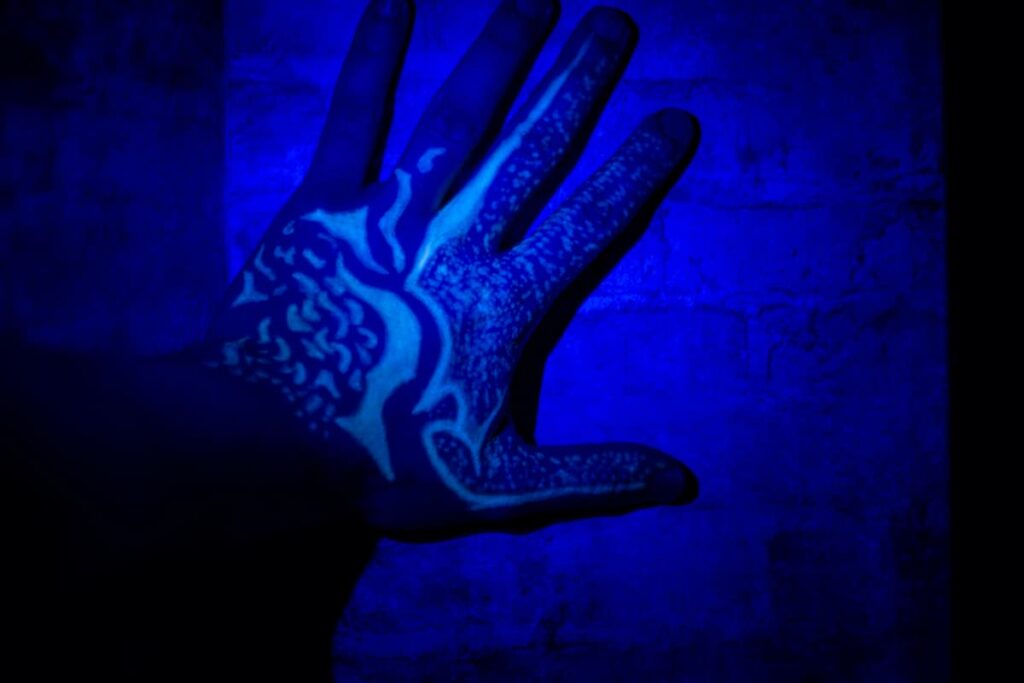 Man's hand with a UV ink tattoo under black light. Best UV tattoo ink.