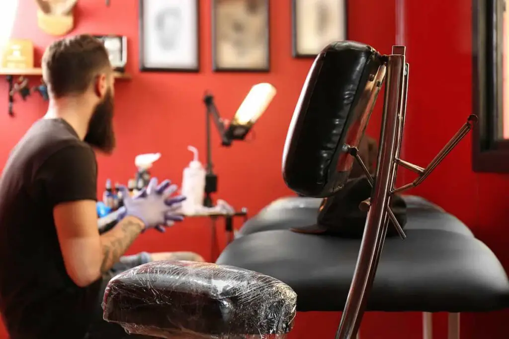 A tattoo artist looking over equipment, including lighting, in his studio.